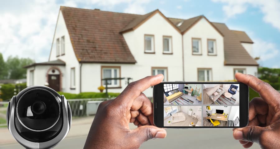 Man holding smartphone and viewing streams from security cameras